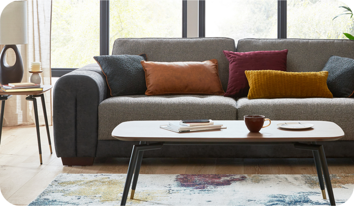 70s inspired living sprace with a two tone sofa made up of dark grey and brown and colourful cushions