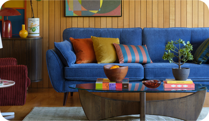 Bright blue sofa in a wooden living space finished with bright cushions and accessories