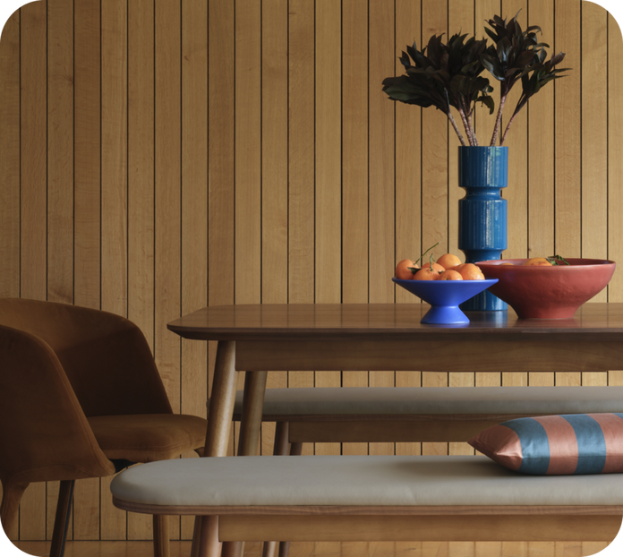 Walnut dining table and bench set with a panelled wooden wall