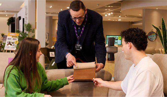 store colleague showing a young man and women a selection of fabric swatches