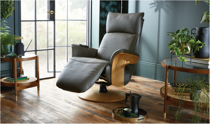 Dark grey reclining swivel chair in a stylish room with plants, wooden flooring, and a large window