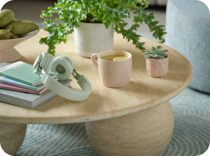 round coffee table and spherical feet with a plant, headphones and books situated on the top