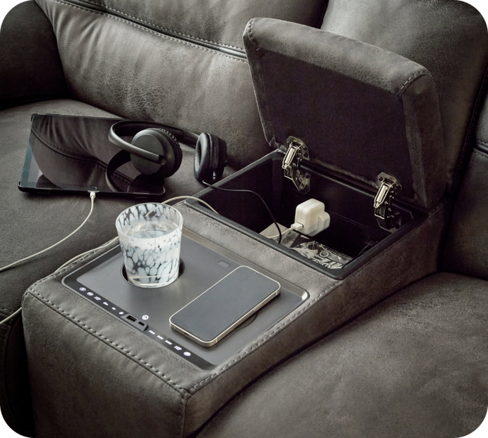 close up of a sofa console with built in cup holders, wireless charging and hidden storage