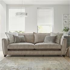 beige fabric sofa with orange and patterned scatter cushions against a large window