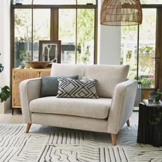 cream fabric cuddler chair with green and monochrome scatter cushion