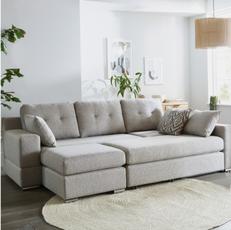 light grey sofa bed with button detailing on the cushions next to a round fluffy rug