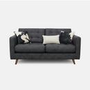Dark grey faux leather sofa with cow print scatter cushions
