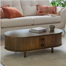 dark wood oval coffee table on a white fluffy rug