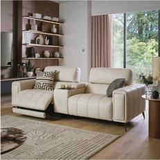 White leather recliner sofa in a cosy living room with wooden shelving and natural light