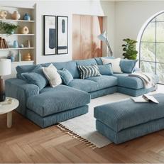 Blue fabric u shaped corner sofa and matching footstool in a cosy living room with wooden flooring