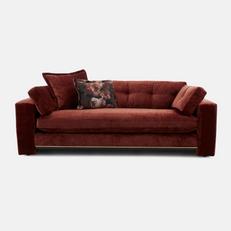 red sofa with gold trim and floral scatter cushion