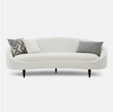 white curved sofa with black and white pattern scatters