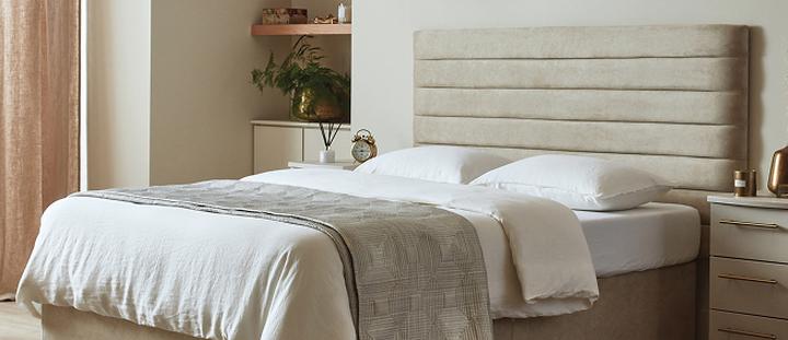 close up of a divan bed with a beige headboard in a neutral setting