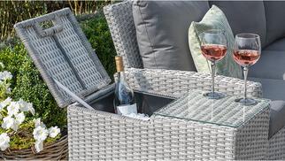 Grey rattan garden furniture with built in ice bucket alongside two wine glasses