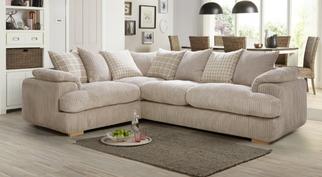beige jumbo corner sofa with neutral pillow back cushions in a bright white room