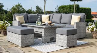 grey rattan garden sofa with a bench and footstool and rising dining table