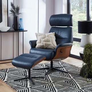 Dark blue swivel chair with matching footstool finished with a dark wood base and sat on a black and white patterned rug