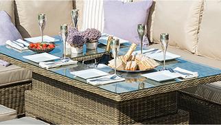 Beige rattan table with buils in ice bucket filled with a bottle of champagne