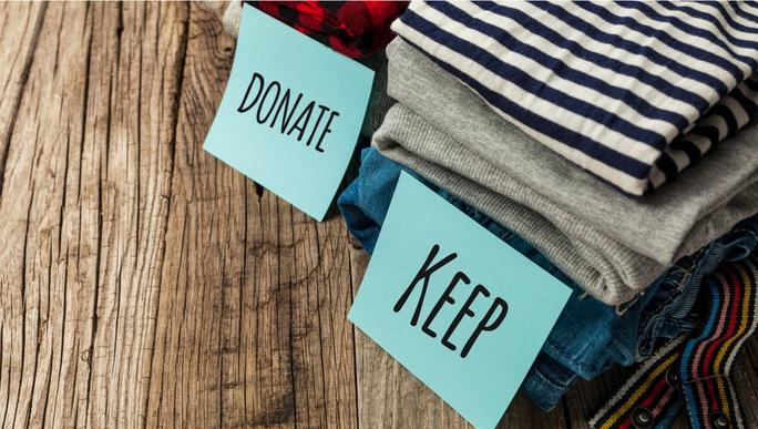 pile of clothes split into a donate or keep pile