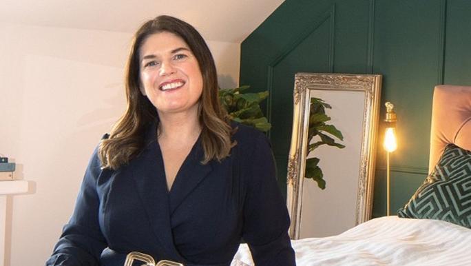 An image of Anne Marie Boyhan smiling in a bedroom