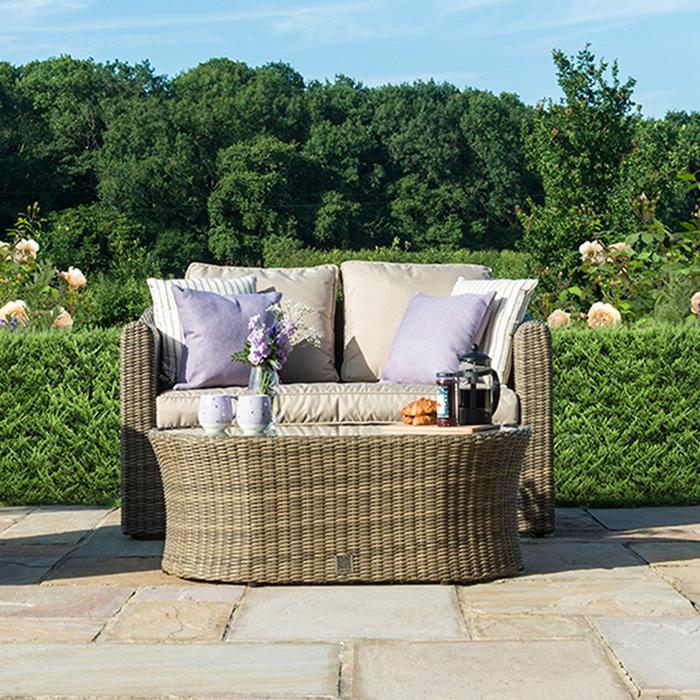 Cream rattan garden sofa with matching coffee table