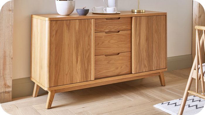 Oak wood sideboard with three drawers down the middle an two doors to the side