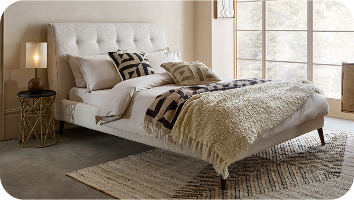 Cream boucle sutdded bed with black leg and neutral bedding