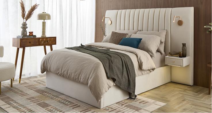 Altea hotel style bed upholstered in cream, with a fluted headboard, built-in bedside shelves and wall lights