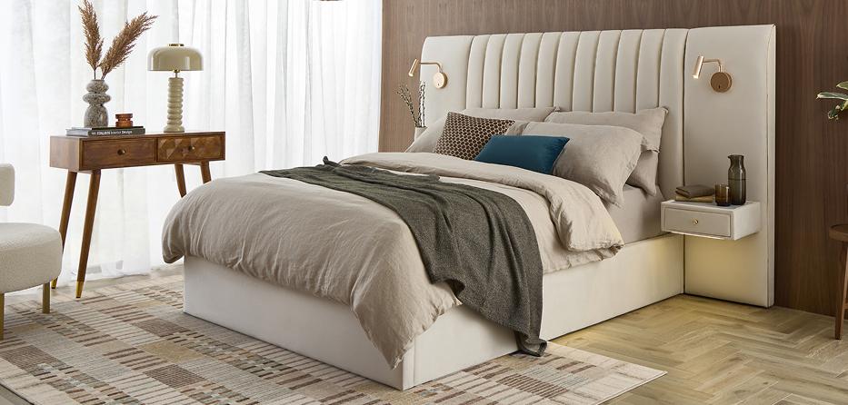 Altea hotel style bed upholstered in cream, with a fluted headboard, built-in bedside shelves and wall lights