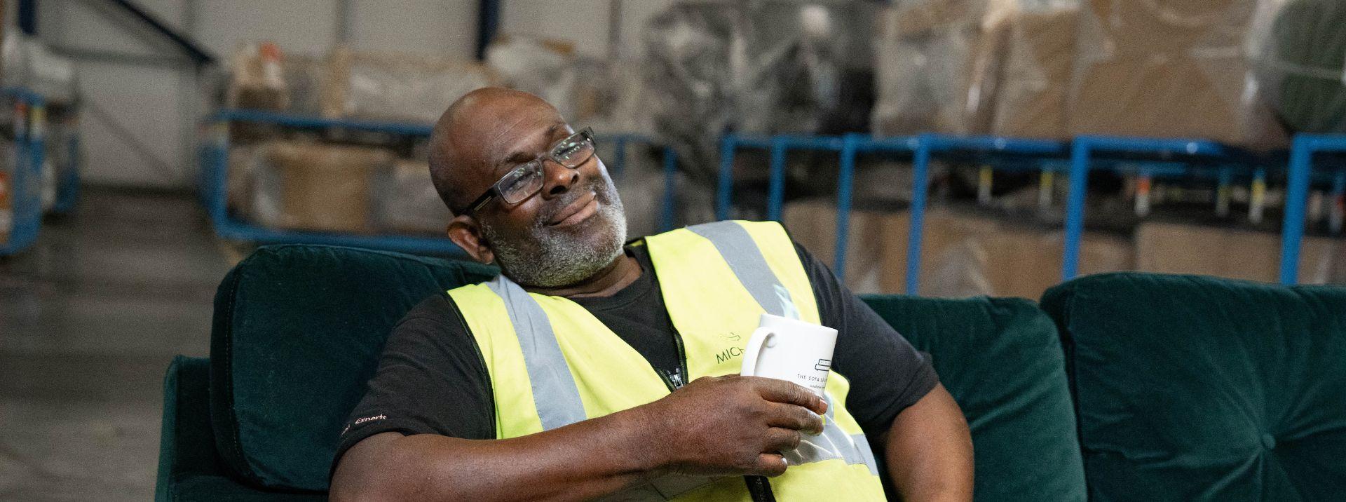 Michael sat on a sofa with a drink